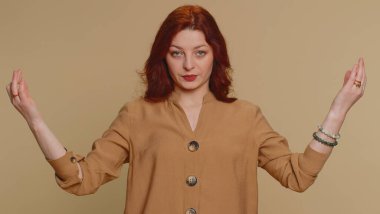 Keep calm down, relax, inner balance. Redhead woman breathes deeply with mudra gesture, eyes closed, meditating with concentrated thoughts, peaceful mind. Young ginger girl on beige studio background