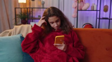 Ergenlik çağındaki bir kız, internet üzerinden akıllı telefon sosyal medya uygulamaları üzerinden rahatlama filmi ve haber içerikli mesajlar atıyor. Küçük çocuk, çocuk gece evde oturuyor oyun odasında turuncu koltukta oturuyor.