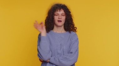 Ok. Joyful happy curly haired woman looking approvingly at camera showing approve feedback gesture like sign positive something good. Young girl on yellow studio background. People sincere emotion