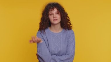 Quarrel. Displeased curly haired woman gesturing hands with irritation and displeasure, blaming scolding for failure, asking why this happened. Young teen girl isolated on yellow studio background