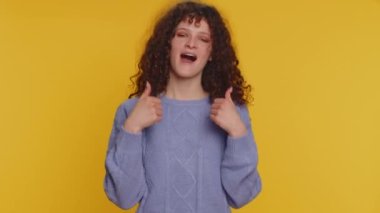 I am the best, choose me. Happy winner curly haired woman feeling very proud pointing herself, looking self-confident, overjoyed by success. Young teen girl isolated alone on yellow studio background