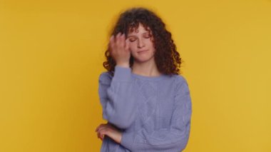 Face palm. Shame on you. Upset curly haired woman making face palm gesture, feeling bored, disappointed in result, bad news, ridiculous joke. Young teen girl isolated alone on yellow studio background
