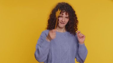 Magician witch woman gesturing with magic wand fairy stick, making wish come true, casting magician spell, advertising holidays sale discount. Young adult girl isolated on yellow studio background