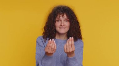 Give me money, please. Woman rubbing fingers show cash gesture, demands to pay back the debt, take loan, do shopping, begging, investment, reward. Young teen girl isolated on yellow studio background