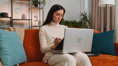 Woman accountant working with documents graph, calculate taxes for charts and graph reports of home income. Businesswoman working on laptop computer with financial bills planning expenses budget
