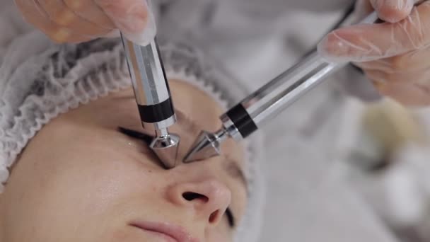 美容师医生让女人面对小电流疗法 女孩皮肤护理在温泉诊所抗老化 美容师用电脉冲进行眼部美容治疗 垂直录像 — 图库视频影像