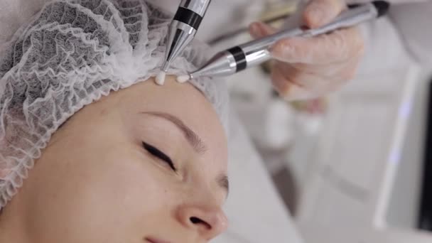 美容师让女人面对小电流疗法 女孩皮肤护理反年龄温泉程序 美容师医生用电脉冲进行面部美容治疗 垂直视频观看拍摄 — 图库视频影像