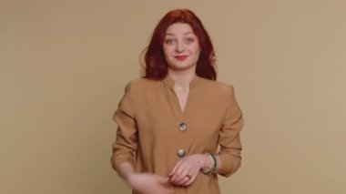 Ok. Joyful happy redhead woman in blouse looking approvingly at camera showing approve feedback gesture like sign positive something good. Young girl on beige studio background. People sincere emotion
