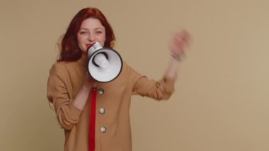 Kızıl saçlı kadın megafonla konuşuyor, haberleri duyuruyor, reklamları yüksek sesle duyuruyor, hoparlörü kullanarak konuşma yapıyor, boş yeri işaret ediyor. Kopyalama uzayı. Bej arka planda genç bir kız