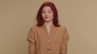 Memnun olmayan kızıl saçlı bir kadın nahoş berbat bir fikre tepki veriyor, kötü kaliteden memnun değil, el sallıyor, başını sallıyor hayır, reddet fikri, evlenme teklifini sevme. Bej renkli stüdyo duvarlı genç kız.