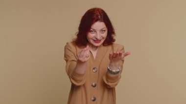 Give me money, please. Woman rubbing fingers show cash gesture, demands to pay back the debt, take loan, do shopping, begging, investment, reward. Young ginger girl isolated on beige studio background