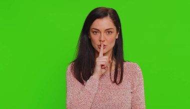 Sessiz olun lütfen. Milenyum kadınının portresi. 30 yaşında. İşaret parmağı dudaklara. Krom anahtar arka planında poz veren güzel bir kız.