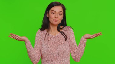Ne diyecegimi bilmiyorum. Kafası karışmış bir kadın belirsiz bir soru hakkında utanmış, kuşkuları var, hiçbir fikri yok, bilgisiz ve kararsız. Yeşil renkli anahtar arka planında izole edilmiş güzel bir kız.
