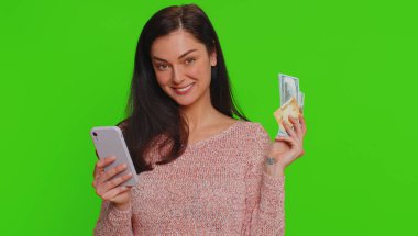 Para transferi, online alışveriş, ödeme yaparken kredi kartı ve akıllı telefon kullanan dürüst bir kadın. Finans ve internet. Genç kız krom anahtar arka planında tek başına izole edilmiş.