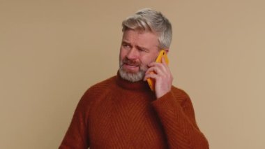 Orta yaşlı bir adam cep telefonuyla konuşan uykulu bir serbest yazar ile çevrimiçi konuşma yapmaktan yoruldu. Bej rengi stüdyo arka planında akıllı telefondan sıkıcı konuşmalar yapan ilgisiz, üzgün, son sınıf öğrencisi.
