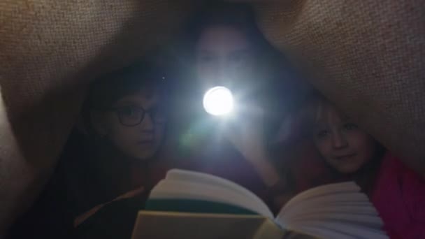 Девочка Подросток Младшие Сёстры Одеялом Клетку Фонариком Читают Интересную Сказку — стоковое видео