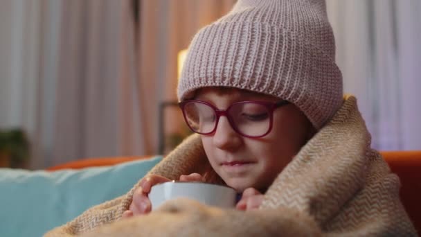 Больной Ребенок Носит Шляпу Завернутую Клетку Сидеть Одиночестве Дрожа Холода — стоковое видео