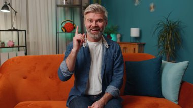 Eureka. Thoughtful clever inspired middle-aged man make gesture raises finger came up with creative plan feels excited with good idea, inspiration motivation at home. Excited amazed mature senior guy