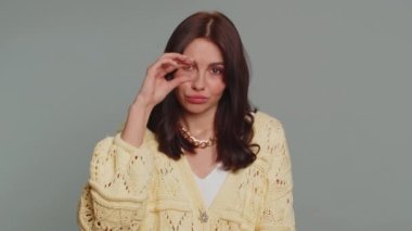 Give me money, please. Woman rubbing fingers show cash gesture, demands to pay back the debt, take loan, do shopping, begging, investment, reward. Young adult girl isolated on gray studio background