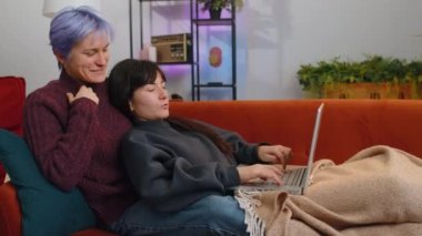 Two lesbian women family couple or girls friends closing laptop pc after finishing work at home. LGBT people. Freelancers working online, remote job. E-learning, browsing internet on notebook computer