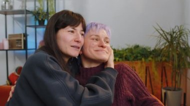 Happy two lesbian women family couple or girls friends smiling friendly, glad expression looking away, relaxation feel satisfied, good news, positive pregnancy test at home. LGBT people IVF maternity