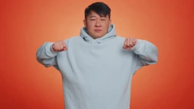 Tired asian handsome man yawning, sleepy inattentive feeling somnolent lazy bored gaping suffering from lack of sleep. Adult guy isolated alone on orange studio background. People lifestyle concept