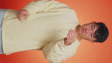 I will not say anyone. Frightened asian man closing mouth with hands, looking intimidated scared at camera. Guy gestures no, refusing to tell terrible secret, unbelievable truth. Vertical video shot