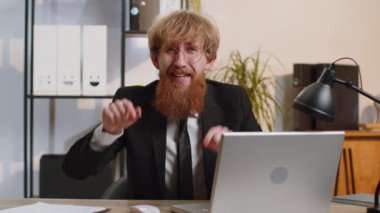 I choose you. Bearded businessman programmer software developer working on office laptop pointing to camera, looking with happy expression, making choice, showing direction. Young freelancer man