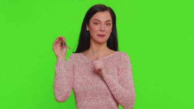 Süveter giyen genç bir bayan emlakçı yeni ev dairesinin anahtarlarını gösteriyor, satın alıyor, kiralıyor, ipotek kredisi veriyor. Milenyum kızı krom anahtar arka planında izole edilmiş