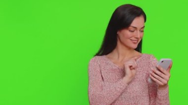Akıllı telefonları boş yeri işaret eden bir kadın, reklam alanı ticari metinler için, ürün tanıtımı için fotokopi alanı sosyal ağlar için pozitif geribildirim. Krom anahtar arka planında izole edilmiş kız