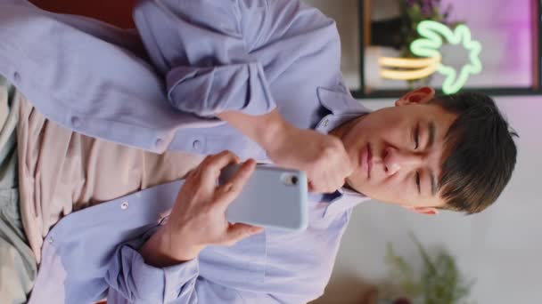 Asiatische Mann Sitzt Auf Sofa Nutzt Smartphone Lächelt Hause Zimmer — Stockvideo