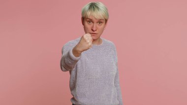 Saldırgan, kızgın, kısa saçlı, kameraya karşı dövüşmeye çalışan, yumruklarını sallayan, ifadeyle boks yapan, cezalandıran bin yıllık kadın. Pembe stüdyo geçmişinde izole edilmiş genç bir kız. Lgbt gay lezbiyen insanlar