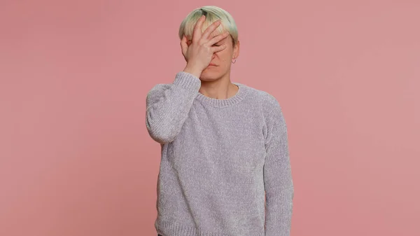 Face palm. Shame on you. Upset millennial woman making face palm gesture, feeling bored, disappointed in result bad news. Young girl isolated on pink studio background. Lgbt gay lesbian people concept