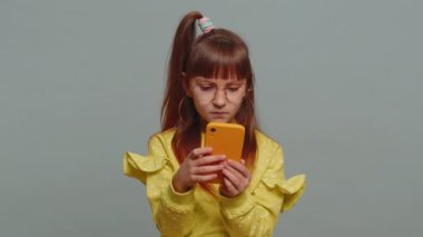 Gözlüklü liseli kız akıllı telefon daktilo kullanıyor. Ani piyango sonuçlarını kaybediyor. Kötü talih, kayıp. Eğitim, eğitim. Gri arka planda genç bayan çocuk
