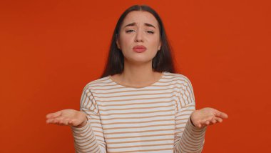 Young pretty woman feeling hopelessness loneliness, nervous breakdown, loses becoming surprised by lottery results, bad fortune, loss, unlucky news. Caucasian girl isolated on studio red background