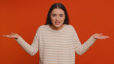 What Why. Sincere irritated woman raising hands in indignant expression asking reason of failure demonstrating disbelief irritation by trouble. Young confused pretty girl isolated on red background