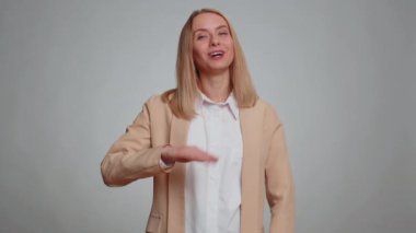 Come here, join us. Welcome. Secretary office woman showing inviting gesture with hands, ask to join, beckoning to coming, gesturing hello or goodbye. Business girl isolated on gray studio background