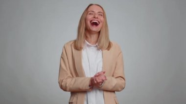 Amused office secretary woman pointing finger to camera, laughing out loud, taunting making fun of ridiculous appearance, funny joke anecdote. Business girl isolated alone on gray studio background