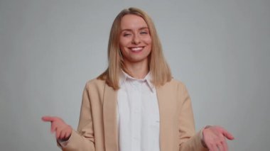 Ben en iyisiyim, beni seç. Genç iş kadınının portresi gururlu bir şekilde kendini gösteriyor, kendinden emin görünüyor, galibiyetten çok memnun. Takım elbiseli kadın. Gri arka planda izole kadın