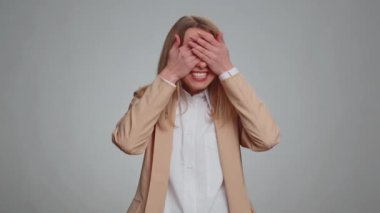 Dont want to look at this, awful. Afraid business woman closing eyes with hand showing stop gesture, confused shy scared to watch. Adult girl isolated on gray studio background. People lifestyles