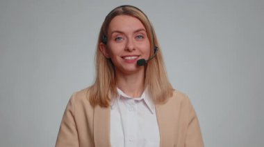 Smiling business woman wearing headset, freelance worker, call center or support service operator helpline, having talk with client or colleague, communication support. Saleswoman on gray background