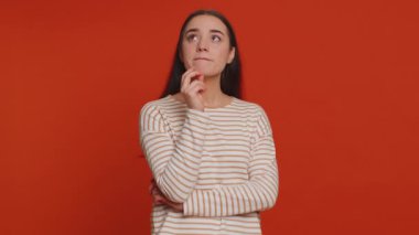 Excited amazed pretty woman in pullover touching head and showing explosion, looking worried and shocked, professional burnout. Looking surprised wow girl isolated alone on red studio wall background