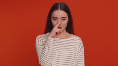 I am watching you. Caucasian woman in pullover pointing at her eyes and camera, show I am watching you gesture, spying on someone. Young adult pretty girl isolated alone on red studio wall background