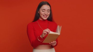 Mutlu güzel bir kadın komik masal kitabı okuyor, boş zaman hobisi, bilgelik, eğitim, öğrenme eğitimi, vay be ilham. Kırmızı stüdyo arka planında yalnız yaşayan genç bir kız.