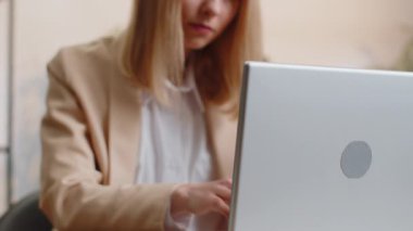 Close-up portrait young blonde businesswoman face freelancer at home office workplace working on laptop computer. Manager freelancer adult woman works on notebook send messages makes online purchases