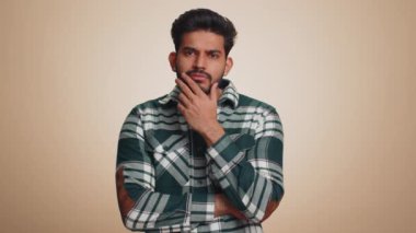 Eureka. Inspired young indian man pointing finger up with open mouth, having good idea, plan, startup, showing inspiration motivation gesture, problem solution. Bearded hindu guy on beige background