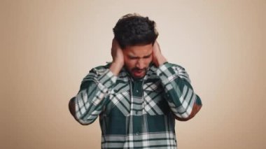 Duymak ve dinlemek istemiyorum. Sinirli, asabi Hintli adam kulaklarını kapatıyor. Hayır, nahoş sesleri duymazdan gelerek tavsiyelerden kaçınıyor. Bej arka planda yalnız yakışıklı Hintli adam.