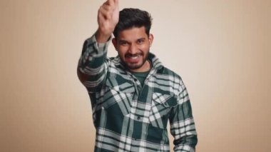 Magician wizard man gesturing with magic wand fairy stick, making wish come true, casting magician spell, advertising holidays sale discount. Handsome indian guy isolated on beige studio background