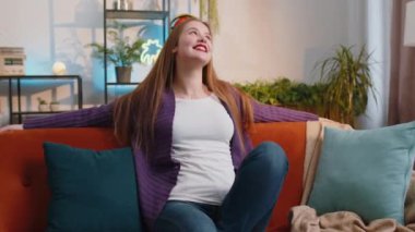 Portrait of happy calm young woman at home couch smiling friendly, glad expression looking away dreaming resting, relaxation feel satisfied concept good news, celebrate win. Girl on living room sofa