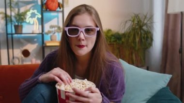 Üç boyutlu gözlüklü heyecanlı kadın koltukta oturup patlamış mısır yiyor ve evdeki sosyal medya içerikli ilginç TV dizisi, spor oyunu, film ve sosyal medya filmleri izliyor. Kız eğleniyor